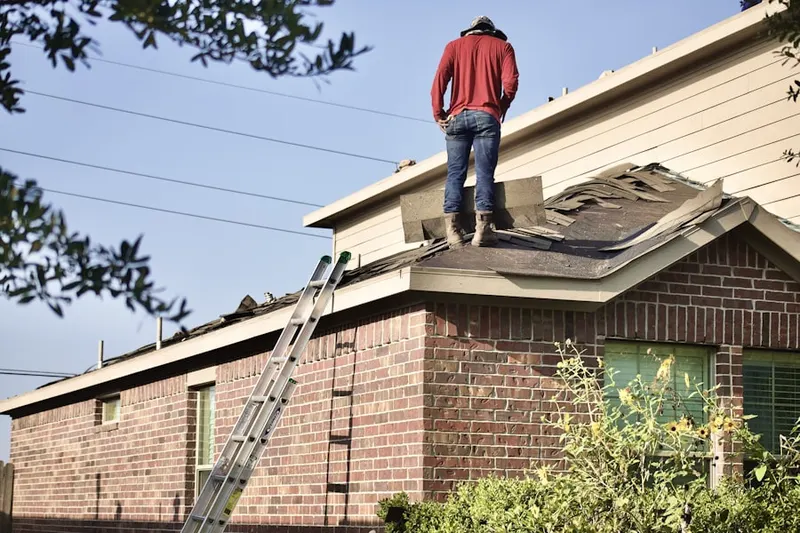 Professional roofer working on a residential roof in Hopedale